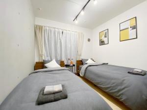 Duas camas num quarto com uma janela em nestay apartment tokyo nippori em Tóquio