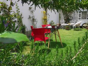 two red chairs and a table in a garden at Casa Fusion Hotel Boutique in La Paz