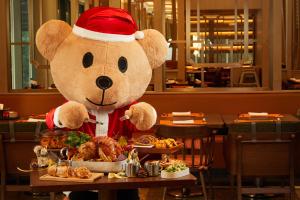 Um ursinho de peluche com um chapéu de Pai Natal à mesa com comida. em Shangri-La Yuanqu, Suzhou em Suzhou