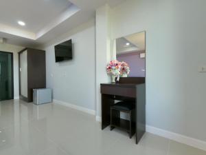 a hallway with a mirror and a table with flowers on it at Khun Ying Hotel in Nan