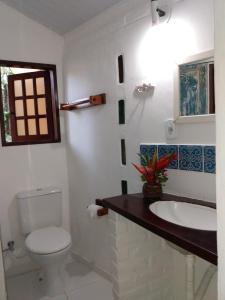 a bathroom with a toilet and a sink at Pousada Atlântida in Arraial d'Ajuda