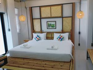 a bedroom with a large white bed with two pillows at Luck Esan Loft in Ubon Ratchathani