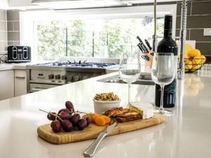 a kitchen counter with a cutting board and wine glasses at Blissful Bungalow in Culburra Beach