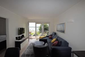 a living room with a blue couch and a tv at Meeresblick-Strandperle-Haus-2-WE-24 in Hohwacht