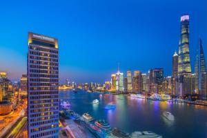 上海上海外滩英迪格酒店的夜晚的城市天际线，有河流和建筑物