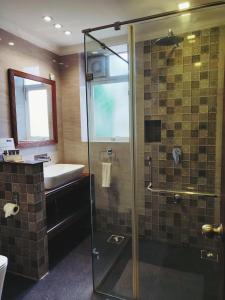 uma casa de banho com um chuveiro e um lavatório. em Santana Beach Resort em Candolim