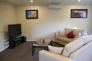 a living room with a couch and a tv at Linton Cottage in Palmerston North