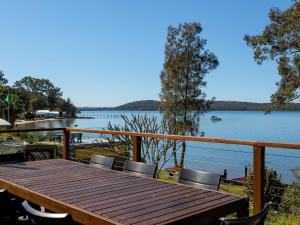 una mesa de madera y sillas con vistas al lago en Paradise 54 Eastslopes Way, en North Arms Cove