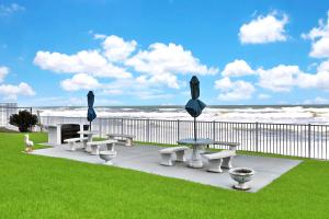 a group of tables and benches on the beach at Rolling Waves in Ormond Beach