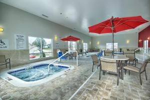 a restaurant with a swimming pool with tables and umbrellas at Holiday Inn Express & Suites Ironton by IHG in Ironton