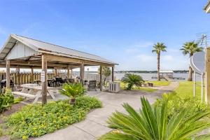 a pavilion with tables and palm trees and the water at Lagoon Landing #302 in Gulf Shores
