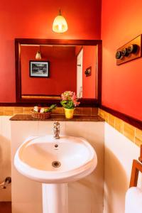 uma casa de banho com um lavatório branco e um espelho. em Teanest by Nature Resorts em Coonoor