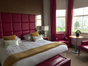 a bedroom with a large bed with a red headboard at Hastings House in Hastings