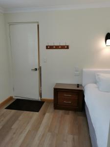 1 dormitorio con cama, puerta y mesa en BHA unit 5 en Perth