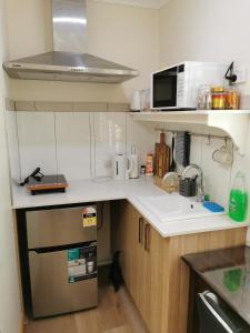 eine kleine Küche mit einer Spüle und einer Mikrowelle in der Unterkunft BHA unit 5 in Perth