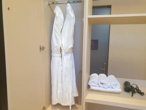a white robe hanging on a wall next to a bed at Hotel Libre in Siheung