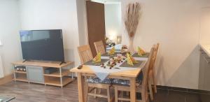 ein Esszimmer mit einem Tisch mit Stühlen und einem TV in der Unterkunft Apartements Breitenwang in Reutte