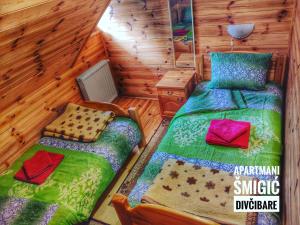 una camera con 2 letti in una baita di tronchi di Apartmani Smigic Divcibare a Divčibare