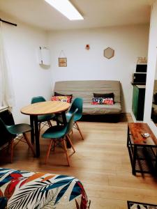 uma sala de estar com uma mesa e um sofá em STUDIOS MAGUI em Ax-les-Thermes