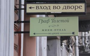 a sign for a flato tomon with a sign for a micangering at Hotel Graf Tolstoy in Saint Petersburg