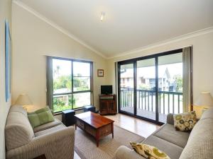 a living room with two couches and a table at Pet Friendly on Pelican Close to Myall River in Hawks Nest