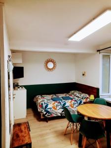sypialnia z łóżkiem, stołem i krzesłami w obiekcie STUDIOS MAGUI w mieście Ax-les-Thermes