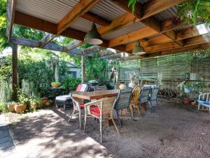 a patio with a table and chairs under a wooden pergola at Sunroom Cottage in Tea Gardens