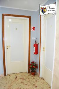 ターラントにあるB&B Taneseの二つのドアと壁に消火器が付いた部屋