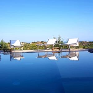 una gran piscina de agua azul con dos pabellones en Cristina & Margot, en Noto