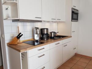 a kitchen with white cabinets and a stove top oven at Ferienwohnung 7 Katharina mit Balkon in Lauterbach