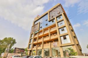 a building with cars parked in front of it at Hotel Sparsh Inn - Chandkheda in Ahmedabad