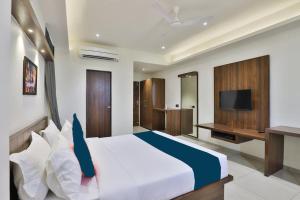 a bedroom with a large bed and a television at Hotel Sparsh Inn - Chandkheda in Ahmedabad