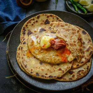 two pancakes on a plate on a table at Hotel Sparsh Inn - Chandkheda in Ahmedabad