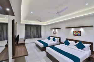 a hotel room with two beds and a television at Hotel Sparsh Inn - Chandkheda in Ahmedabad +58 photos