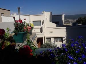 un edificio blanco con flores delante en Oren's place - perfect for families & friend's en Kefar Weradim