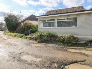 a house with a puddle of water on a driveway at Driftwood in Wadebridge