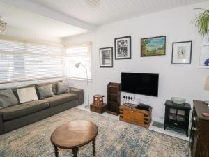 a living room with a couch and a flat screen tv at Driftwood in Wadebridge