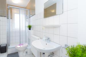 ein weißes Badezimmer mit Waschbecken und Toilette in der Unterkunft Private rooms next to subway in Nürnberg