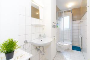 bagno bianco con lavandino e servizi igienici di Private rooms next to subway a Norimberga