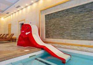 a slide in a swimming pool in a building at 7 Pools Boutique Hotel & SPA in Bansko