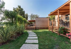a garden with a pathway leading to a house at Fornella Camping & Wellness family resort in San Felice del Benaco
