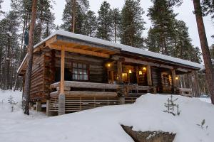 eine Blockhütte im Wald im Schnee in der Unterkunft Kelokolo, Ivalo in Ivalo