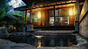 a house with a pond in front of it at Tirta Arsanta Hot Springs & Villa in Bogor