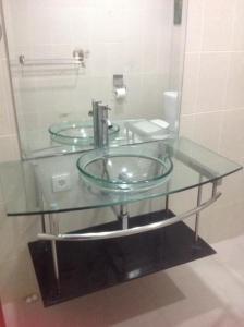 a glass counter top with a sink in a bathroom at Bali Senia Hotel in Sanur