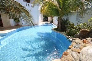 a swimming pool with a palm tree next to a building at Hotel Bahia Huatulco in Santa Cruz Huatulco