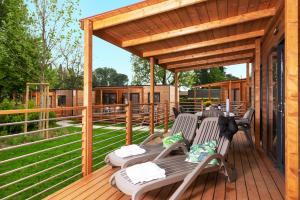 a wooden deck with chairs and a pavilion at Fornella Camping & Wellness family resort in San Felice del Benaco