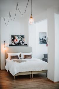 ein Schlafzimmer mit einem Bett in einem weißen Zimmer in der Unterkunft THE LOFT LODGE - Suiten in Braunschweig