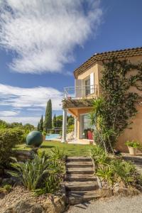 uma casa com uma escada em frente a um quintal em Villa Lili Rose em Le Lavandou