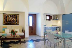 a living room with a couch and a table and a kitchen at Dammusi e Relax in Pantelleria