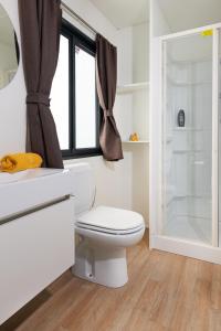 a white bathroom with a toilet and a shower at Fornella Camping & Wellness family resort in San Felice del Benaco